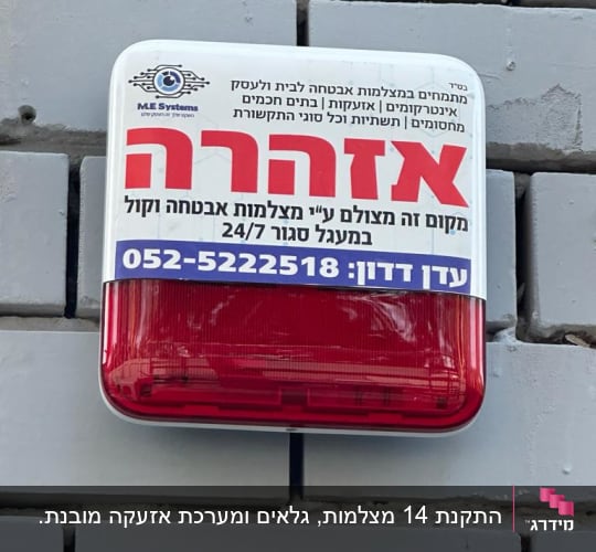 שלט אזהרה על קיר עם פרטי מצלמות אבטחה